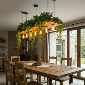 Peut inclure: Une salle à manger rustique avec une grande table en bois et des chaises assorties. Au-dessus, un luminaire unique combine une base en bois, de la verdure suspendue et des ampoules de style vintage. L'ambiance est chaleureuse et naturelle.