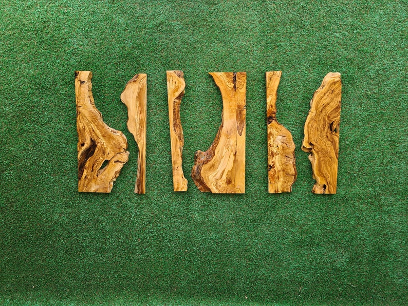 May include: Five pieces of wood with a natural wood grain pattern and irregular shapes. The wood is light brown and has a rustic appearance.