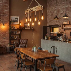 May include: Interior shot of a cafe with a long wooden table and chairs. A rustic light fixture hangs above the table, with exposed light bulbs. The walls are brick, and there is a coffee bar in the background.