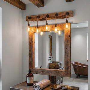 Puede incluir: Un espejo de pared rectangular con un marco de madera marrón desgastada y gruesa. Sobre el espejo, una viga de madera a juego sostiene cinco lámparas colgantes con bombillas tipo Edison expuestas, suspendidas por cuerdas gruesas.