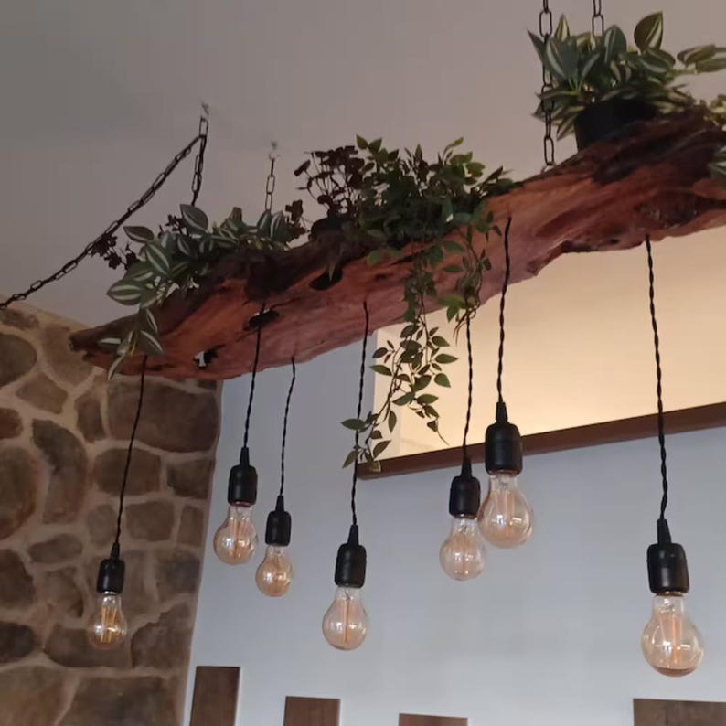 May include: A rustic wooden light fixture with a natural wood finish and black wire hanging light bulbs. The fixture is decorated with green plants.