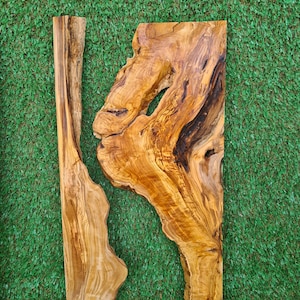 May include: Two pieces of natural wood with a unique grain pattern. The wood is light brown with darker brown streaks. The wood is shaped like a rectangle and has a rough, natural edge.