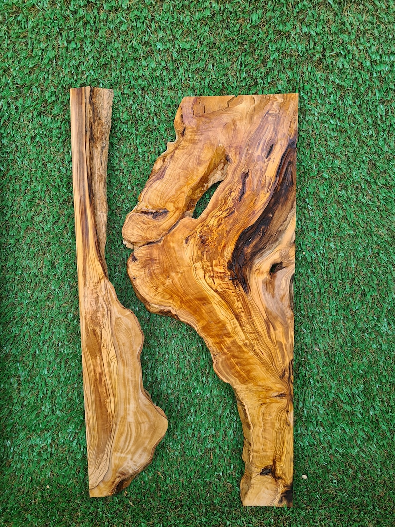 May include: Two pieces of natural wood with a unique grain pattern. The wood is light brown with darker brown streaks. The wood is shaped like a rectangle and has a rough, natural edge.