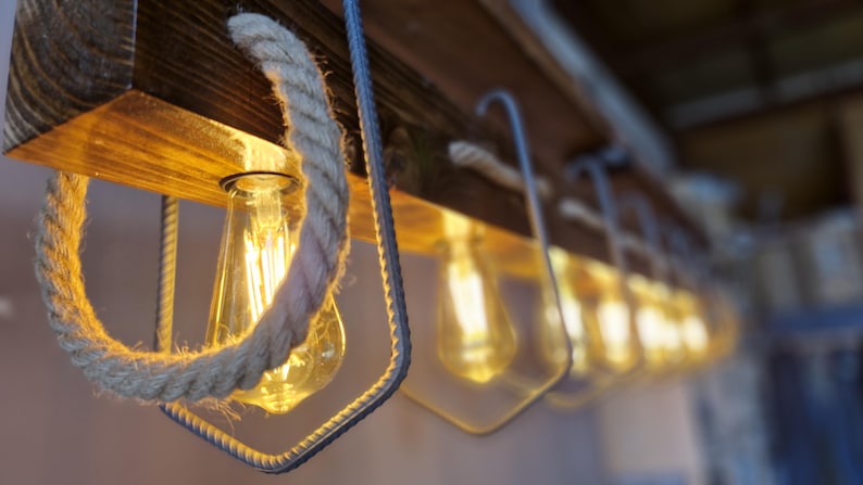 Puede incluir: Una l&aacute;mpara de madera r&uacute;stica con bombillas expuestas y detalles de cuerda. La l&aacute;mpara tiene una est&eacute;tica c&aacute;lida y acogedora y es perfecta para a&ntilde;adir un toque de encanto r&uacute;stico a cualquier espacio.