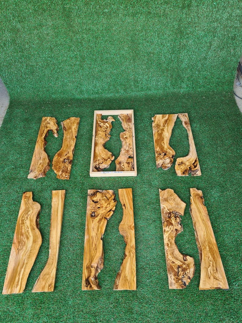Puede incluir: Un conjunto de ocho piezas de madera con veta de madera natural y nudos. Las piezas son de varios tama&ntilde;os y formas, algunas con un agujero en el centro. La madera es de color marr&oacute;n claro con vetas marrones m&aacute;s oscuras.