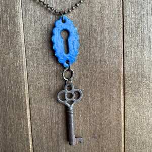 May include: A blue keyhole charm necklace with a vintage-style skeleton key pendant.