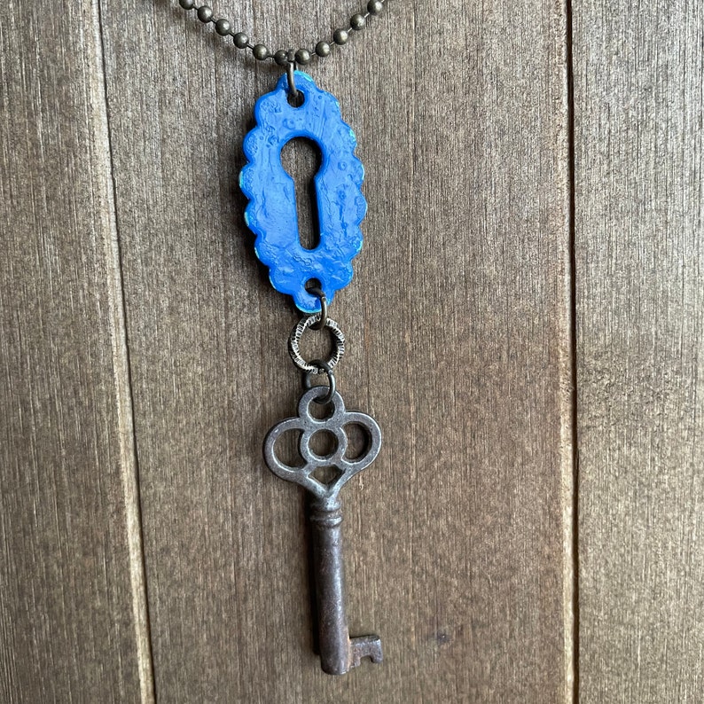 May include: A blue keyhole charm necklace with a vintage-style skeleton key pendant.