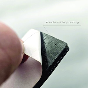 Peeling off the protective layer of the self-adhesive loop backing included with the Task Failed Successfully meme patch, perfect for mounting on PC cases or monitors.