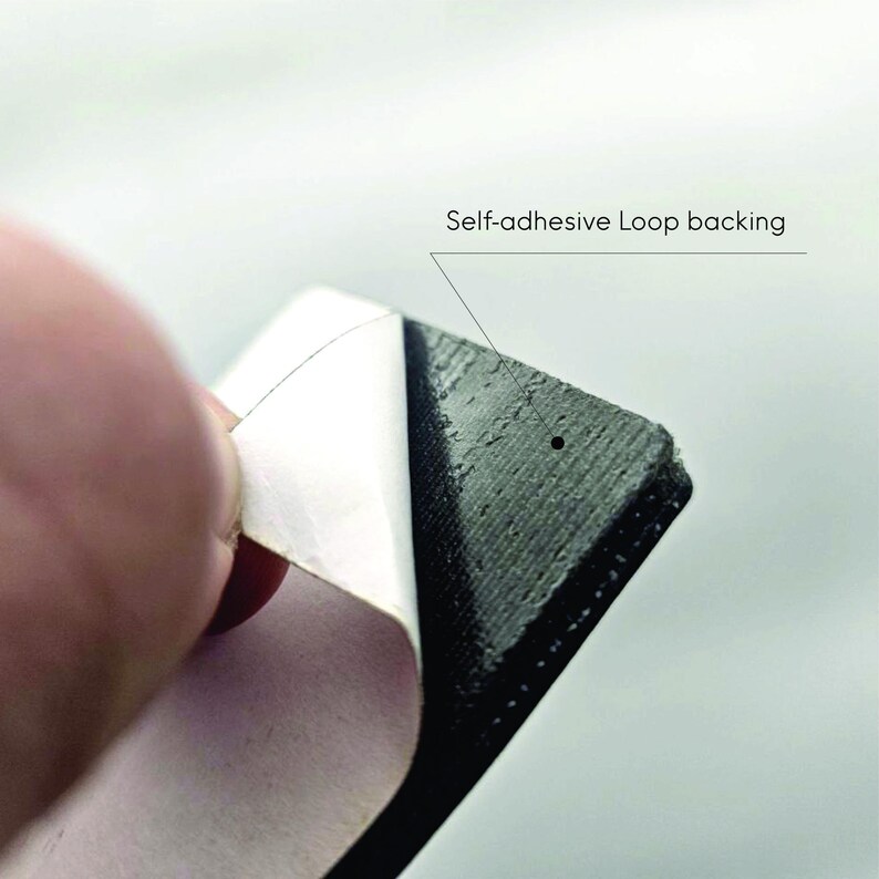 Peeling off the protective layer of the self-adhesive loop backing included with the Task Failed Successfully meme patch, perfect for mounting on PC cases or monitors.