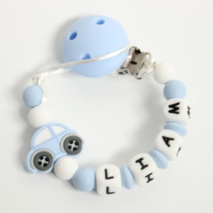 May include: A blue and white silicone baby teether with a car charm and the name "WILL" spelled out in black letters.