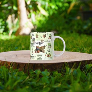 May include: White ceramic mug with a green and brown design featuring gardening-themed illustrations and text that reads "Bloom and Grow", "Gardener Life", and "Plant the Seed".