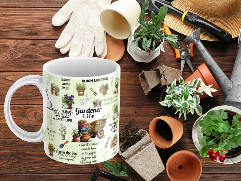 May include: White ceramic mug with a green, brown, and yellow design featuring gardening tools, plants, and the text "Gardener Life". The mug is surrounded by gardening tools, plants, and soil.