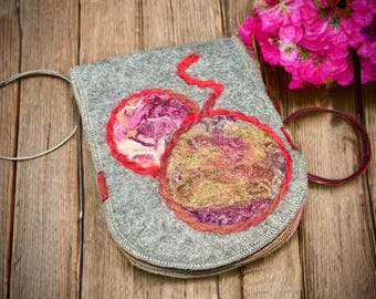 Könnte beinhalten: Eine graue Filztasche mit Reißverschluss zeigt ein handgefilztes Design aus zwei Kirschen mit roten Stielen. Die Kirschen sind aus bunten Wollfasern in den Farben Rosa, Lila, Gelb und Grün gefertigt.