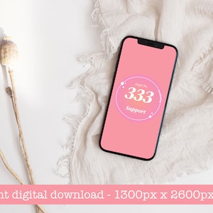 May include: A pink phone screen with a white circle containing the text "Angel No. 333 Support" on a white fabric background.