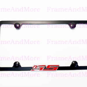 May include: Black license plate frame with rounded corners and four black ball-shaped screw covers. The frame has a red and silver "SS" emblem at the bottom. The background is white.