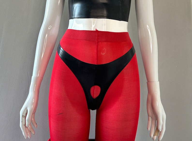 Puede incluir: Leggings rojas con un panel de l&aacute;tex negro y un recorte en la parte delantera.