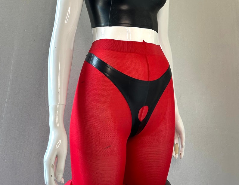 Puede incluir: Leggings rojas con un panel de cuero negro y un detalle de corte.