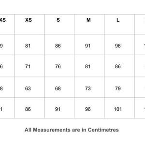 May include: A black and white size chart table with columns for XXS through XXL sizes and rows for Bust, Under Bust, Waist, and Hip measurements. The table displays numerical values in centimetres for each category, with the text All Measurements are in Centimetres at the bottom.