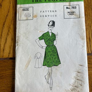 May include: A vintage sewing pattern from "The People" featuring a green and white dress design. The pattern is labelled "MATRON'S DRESS" and "SIZE 48". The text on the pattern reads "The People" Paper Pattern Service, 1/2 Slingsby Place, Long Acre, London, W.C.2.