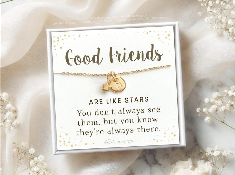 May include: A white card with gold glitter and the text "Good Friends Are Like Stars You don't always see them, but you know they're always there."  RekCOLLECTION is printed at the bottom of the card. A gold necklace with a star and a letter charm is displayed on the card.