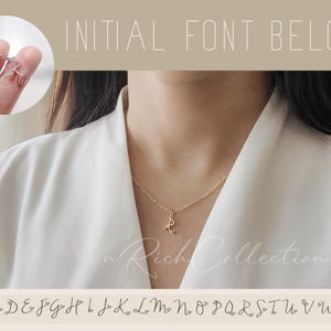 Op de afbeelding: Een gouden ketting met een hanger in een cursief lettertype. De afbeelding toont de hanger met de letter 'R', maar het lettertype is beschikbaar voor alle letters van het alfabet. Het alfabet wordt onder de afbeelding weergegeven.