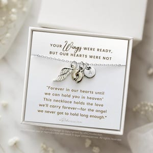 May include: A silver necklace with a small angel wing charm, a footprint charm, and a letter charm. The necklace is in a white box with a message that reads "Your Wings Were Ready, But Our Hearts Were Not."  "Forever in our hearts until we can hold you in heaven. This necklace holds the love we'll carry forever-for the angel we never got to hold long enough."