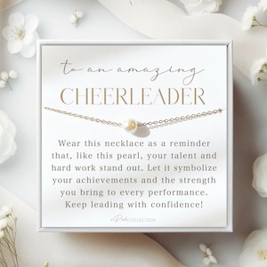 以下が含まれることがあります： 「to an amazing CHEERLEADER」と金色の文字で書かれた白いカード。カードは白い箱に入っていて、単一の真珠のペンダントが付いた金色のチェーンネックレスが入っています。カードには、「このネックレスを、この真珠のように、あなたの才能と努力が際立つことを思い出させてくれるものとして身につけてください。あなたの功績と、あらゆるパフォーマンスにもたらす力を象徴させてください。自信を持って、先頭に立ち続けてください！」と書かれています。