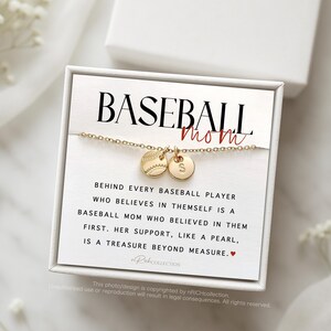 May include: A white box with a gold necklace featuring a baseball charm and a letter charm. The box has the text "BASEBALL mom" and a quote about the importance of a baseball mom's support.