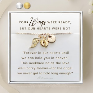 May include: A gold necklace with a charm of a small angel wing, a baby footprint, and a letter 'S' charm. The necklace is in a white box with the text "YOUR Wings WERE READY, BUT OUR HEARTS WERE NOT" and "Forever in our hearts until we can hold you in heaven" This necklace holds the love we'll carry forever-for the angel we never got to hold long enough."