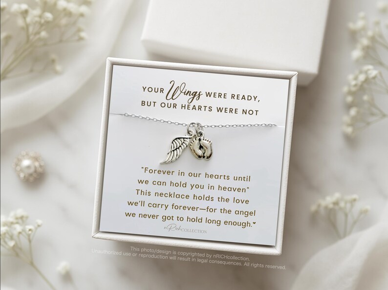 May include: A silver necklace with a small angel wing charm and a charm of two tiny footprints. The necklace comes in a white box with a message that reads "Your wings were ready, but our hearts were not. Forever in our hearts until we can hold you in heaven. This necklace holds the love we'll carry forever - for the angel we never got to hold long enough."