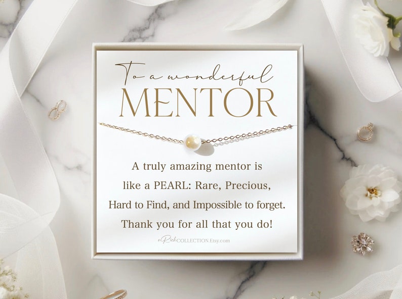 May include: A white card with gold lettering reads "To a wonderful MENTOR. A truly amazing mentor is like a PEARL: Rare, Precious, Hard to Find, and Impossible to forget. Thank you for all that you do!"  A delicate gold chain necklace with a pearl pendant is displayed on the card.
