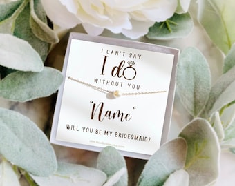Pode incluir: Um delicado colar de prata com um pendente de pérola, apresentado numa caixa de presente. O cartão no interior diz "I can't say I do without you", seguido de "Name" e "Will you be my bridesmaid?" Ideal para um casamento.
