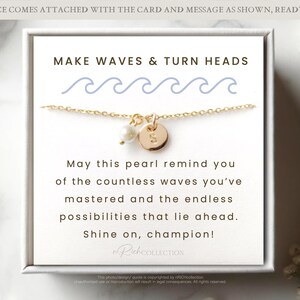 May include: A white card with the text "MAKE WAVES & TURN HEADS" and a gold necklace with a pearl and a gold disc charm. The card also includes the text "May this pearl remind you of the countless waves you've mastered and the endless possibilities that lie ahead. Shine on, champion!"