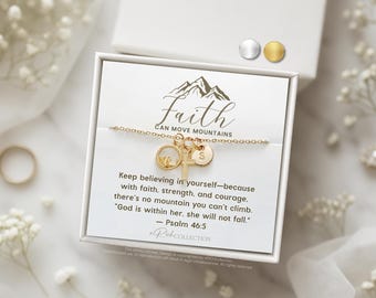 May include: A gold necklace with a charm that says "Faith Can Move Mountains" and a mountain charm. The necklace is in a white box with a quote about faith and Psalm 46:5.