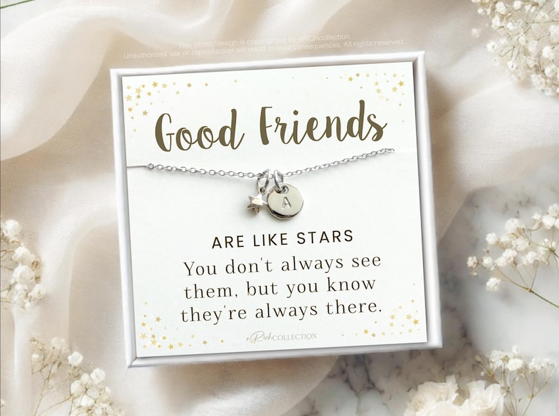 May include: A silver necklace with a star charm and a letter 'A' charm. The necklace is displayed on a white card with gold glitter and the text "Good Friends Are Like Stars You don't always see them, but you know they're always there."