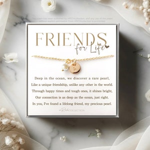 May include: A gold necklace with a pearl charm and a gold disc charm with the letter "S" on it. The necklace is in a white box with the text "FRIENDS for Life" and a poem about friendship.