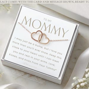 May include: A white gift box with a card that reads "To My Mommy" and a message about a bump loving their mother. The card is accompanied by a gold necklace with two intertwined heart charms.