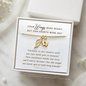 May include: A gold necklace with a small angel wing and footprint charm. The necklace comes in a white box with a message that reads "Your wings were ready, but our hearts were not. Forever in our hearts until we can hold you in heaven. This necklace holds the love we'll carry forever - for the angel we never got to hold long enough."