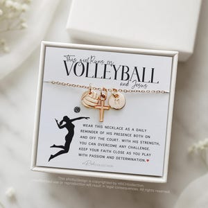 May include: A white box with a gold necklace inside. The necklace has a volleyball charm, a cross charm, and a letter charm. The box has a message that says "This girl runs on volleyball and Jesus".
