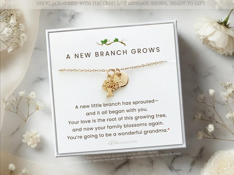 May include: A gold-colored necklace with a tree charm and a round charm, presented on a white card. The card reads "A New Branch Grows" with a message about family. The necklace is ready to gift.