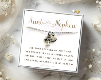 May include: A silver necklace with a tree charm and a small circle charm. The necklace comes in a white box with a gold inscription that reads "Aunt & Nephew". The box also includes a quote about the bond between an aunt and nephew.