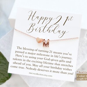 May include: A card with the text "Happy 21st Birthday" and a rose gold necklace with a heart charm and a letter "M" charm. The card includes a message about turning 21 and the necklace is 16 inches long with a 3 inch extension.