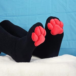 Calcetines de peluche rojos con almohadillas para las patas de Mochi negros hasta el muslo