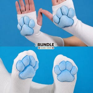 May include: White fingerless gloves and white socks, both featuring plush, light blue animal paw pads. The image includes the text BUNDLE GLOVES + SOCKS with small paw print icons, set against a solid blue background.
