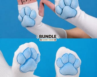 May include: White fingerless gloves and white socks, both featuring plush, light blue animal paw pads. The image includes the text BUNDLE GLOVES + SOCKS with small paw print icons, set against a solid blue background.