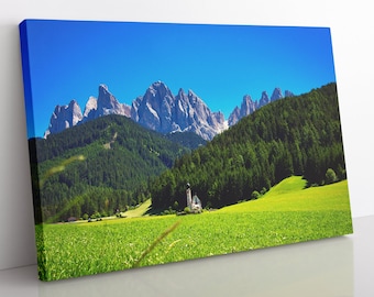 May include: A picturesque landscape featuring a small white church nestled in a valley surrounded by lush green meadows and towering mountains under a bright blue sky.