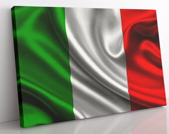 Op de afbeelding: Een close-up van de Italiaanse vlag, met de kleuren groen, wit en rood die in een golfachtig patroon stromen. De vlag is gemaakt van een zijdeachtig materiaal en heeft een licht getextureerd oppervlak.