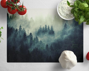 Peut inclure: Une planche à découper bleu foncé et verte avec une image de forêt brumeuse de style aquarelle. L'image présente une variété d'arbres et un effet atmosphérique brumeux.