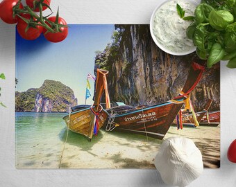 May include: A colorful cutting board with a scenic image of three traditional Thai longtail boats docked on a sandy beach with turquoise water and lush green cliffs in the background. The text "อ่าวพังงา" is visible on one of the boats.