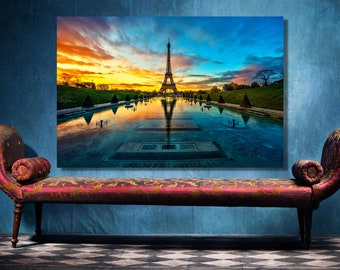 Op de afbeelding: Een kleurrijk canvasprint met een panoramisch uitzicht op de Eiffeltoren in Parijs, Frankrijk. De afbeelding toont de toren die wordt weerspiegeld in een waterpoel bij zonsondergang.